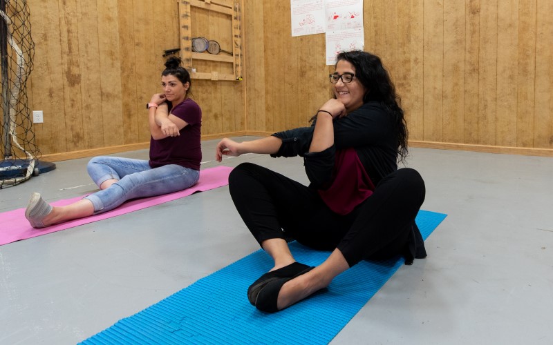 Two women stretch during a yoga session at Cove Forge Behavioral Health